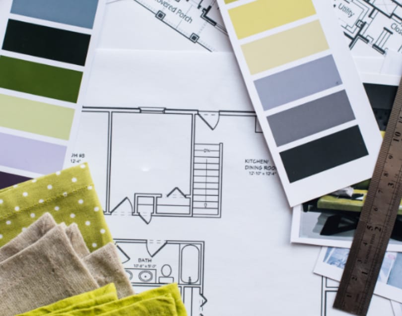 Floorplan layout with paint swatches, fabric samples, and design materials